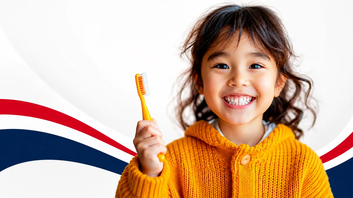 A smiling child holding a toothbrush at Locust Dental Group
